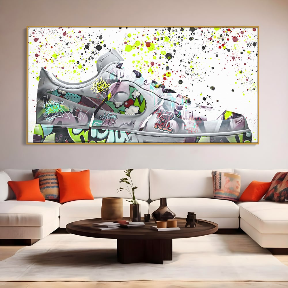 Tablou canvas cu tablou canvas cu adidasi graffiti, in rama de aluminiu auriu, pe perete intr-un living